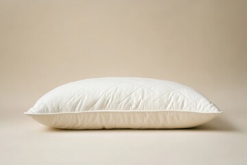 A Clean White Pillow Resting Against a Cream Colored Background