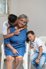 Fototapeta premium Grandchildren showing affection to their grandmother at home