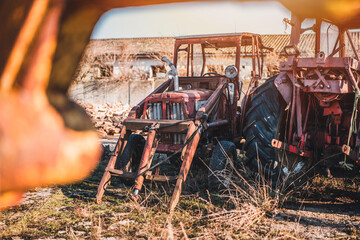 Abandoned old red tractor. Blue sky in background. Old tractor wreck.