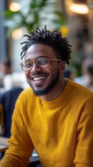 Fototapeta premium Cheerful young man smiling and wearing glasses in coworking space