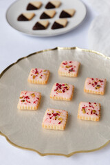 Colorful assorted cookies arranged on a decorative plate in a cozy kitchen setting