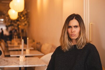 Photo portrait of nice young woman offended angry upset gloomy wear trendy knitwear black sitting...