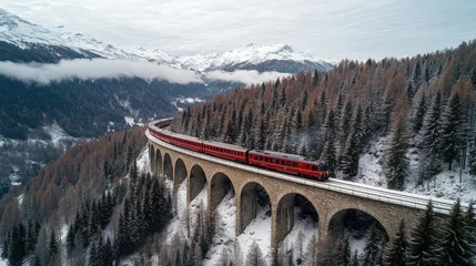 Train crossing the landwasser viaduct bridge in a snowy mountain landscape world heritage site