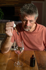 Microdose, Man with a dropper pipette taking the micro dose drug. Medicine CBD, LSD and cannabis oil in liquid form. Psychedelic, hallucinogenic. Alternative medicine.
