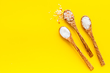 Different kind of sea salt in wooden spoon, top view. Salt for spa, salt baths or cooking