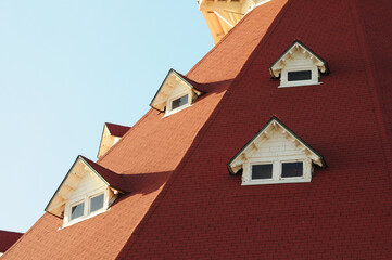 Red-roofed gables against clear sky, classic architecture meets coastal vibes