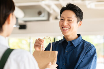テイクアウト商品を受け取るミドルの男性