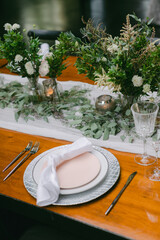 Elegant dining setup with floral arrangements and candles for a sophisticated gathering in an intimate setting