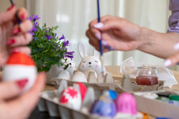 Family paints Easter eggs with a brush and paints, diy easter concept