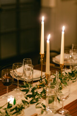 Elegant dining setup with candles and greenery for a cozy evening gathering