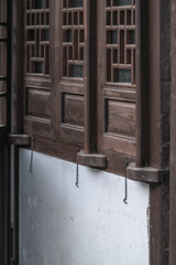 This photo captures a set of traditional wooden windows attached to a wall. The windows are crafted from dark - toned wood, featuring a grid - like lattice pattern. 
