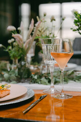 Elegant dining table set with fresh flowers, a gourmet dish, and chilled drinks in a cozy restaurant atmosphere