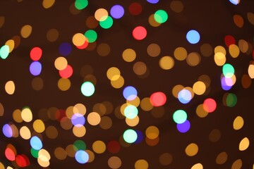 Blurred view of colorful lights on dark background, bokeh effect