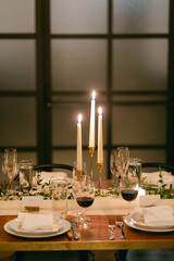 Elegant dinner setting with candles and wine glasses for an intimate gathering in a warm atmosphere