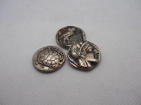 Greek silver coins, Athenian owl and Aegina turtle.