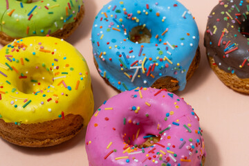 Colorful donuts on pink background. Closeup.