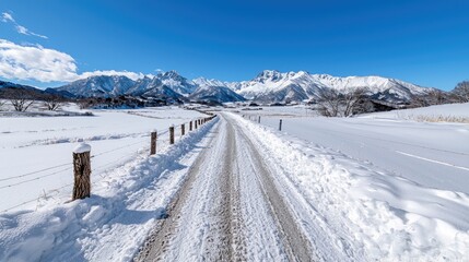 Snowy road towards mountains, winter landscape