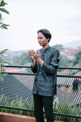 Young muslim man praying outside, seeking blessings in a quiet moment