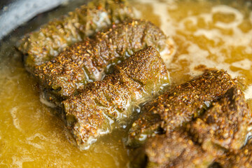 Dolma homemade with meat stewed in a frying pan in broth and spices close-up