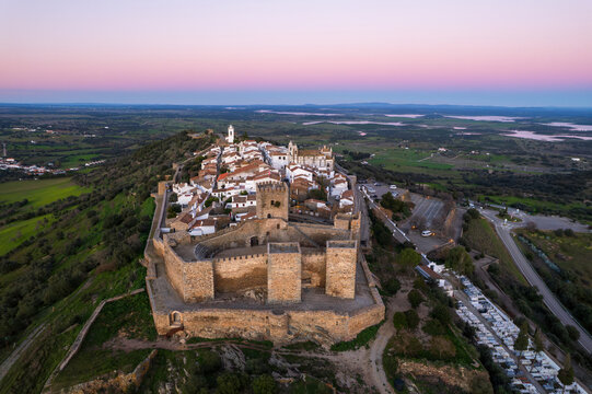 Amazing aerial view of the medieval village of Monsaraz, Alentejo, Portugal. Beautiful landscape at sunset. Historic castle, tourist attraction and holiday travel destination.