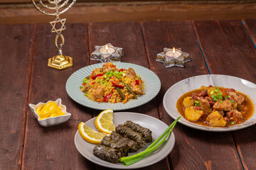 Menorah lighted candles in candlesticks with the Star of David at the set table