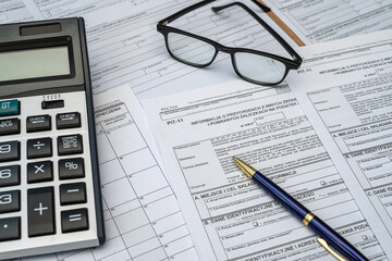 Polish PIT 11 37 38 tax form prepared to be filled with pen calculator glasses on desk