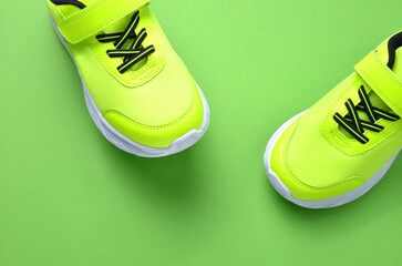 Modern green sneakers for men or women unisex , on a green background. A pair of casual sports shoes.