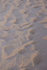 Dry beach sand with footprints and shoe soles.