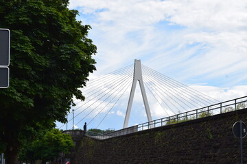 suspension bridge behind an old wall, low angle