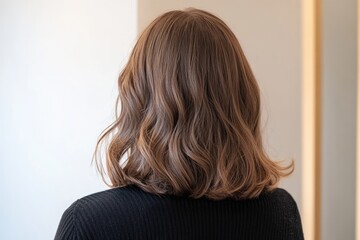 Fototapeta premium The Woman Has Beautiful Long Brown Wavy Hair Style