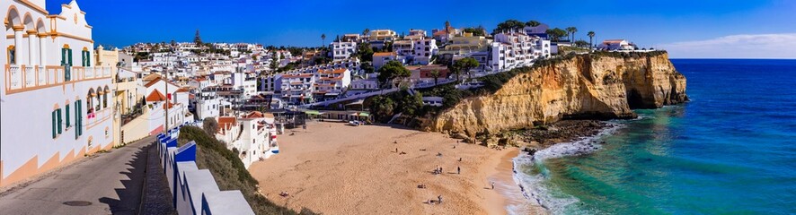 Portugal, beauiful  sunny Algarve coast. Panorama of scenic coastal town Carvoeiro with nice golden beach and white houses