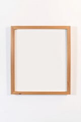 Wooden frame hanging on a white wall, offering a clean and minimalist aesthetic for art or photos.