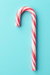 Pastel red and white candy cane on light blue background, sweet tooth, holiday theme, pastel colors