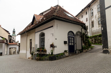 Traditional old house in a historic European town. A charming corner building with a tiled roof and rustic details. Picturesque street with architectural heritage.