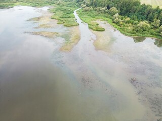 River running through dried up cracked earth bed affected by drought