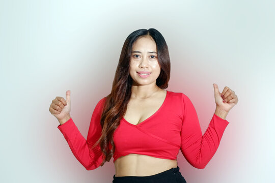 Smiling Asian woman wearing sportswear showing two thumbs up isolated on a white background.