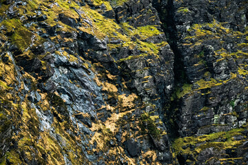 The Carrauntoohil walkway in Ireland, taking in breathtaking views of rocky cliffs and vibrant greenery. The trail offers a challenging adventure for nature enthusiasts.