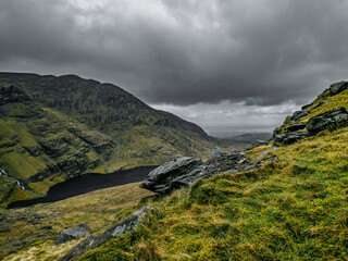 Venturing along the Carrauntoohil walkway reveals stunning vistas of rugged mountains and serene lakes under a dramatic sky. Nature's beauty captivates every hiker in this Irish paradise.