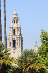 Historic towers rise amidst lush greenery in sunny Balboa Park, San Diego.