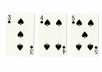 A hand of playing cards showing a run of three on a white background.