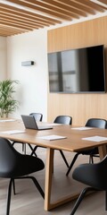A large wooden table with a laptop and a TV in front of it. The table is surrounded by black chairs