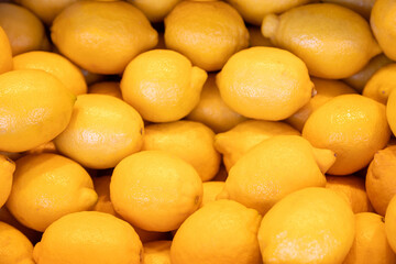 Fresh yellow lemons at a farmers market. Vibrant citrus fruit with a glossy texture. Ideal for food photography, organic produce, healthy lifestyle visuals, and citrus-themed designs