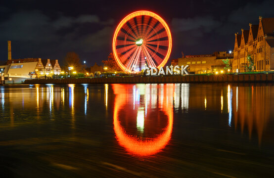 Devil’s Wheel in Gdańsk – Red Ferris Wheel Reflecting in Night Waters with Neon Glow