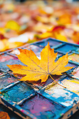 vibrant painter palette adorned with autumn leaf, showcasing earthy tones and colors. scene evokes creativity and nature beauty