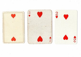 Vintage playing cards in three different designs showing the same value.