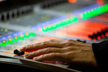 Sound engineer controls the settings on the mixing console panel in sound recording studio for music, sound recording, concert activities