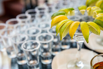 Buffet table with lime on a plate and shot glasses with salt. Serving on a holiday at an event