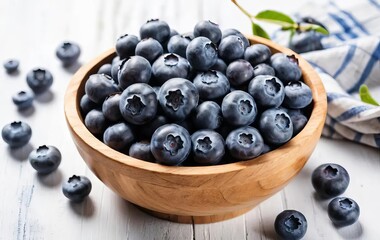 A wooden bowl filled with fresh blueberries on a white table with a rustic background