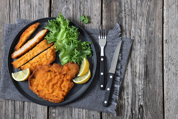 Pork Milanese with lettuce and lemon on a plate