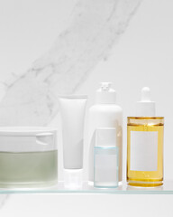 Beauty products for facial skin care on white background. Cleanser soap, serum, moisturizing cream and toner. Mockup.
